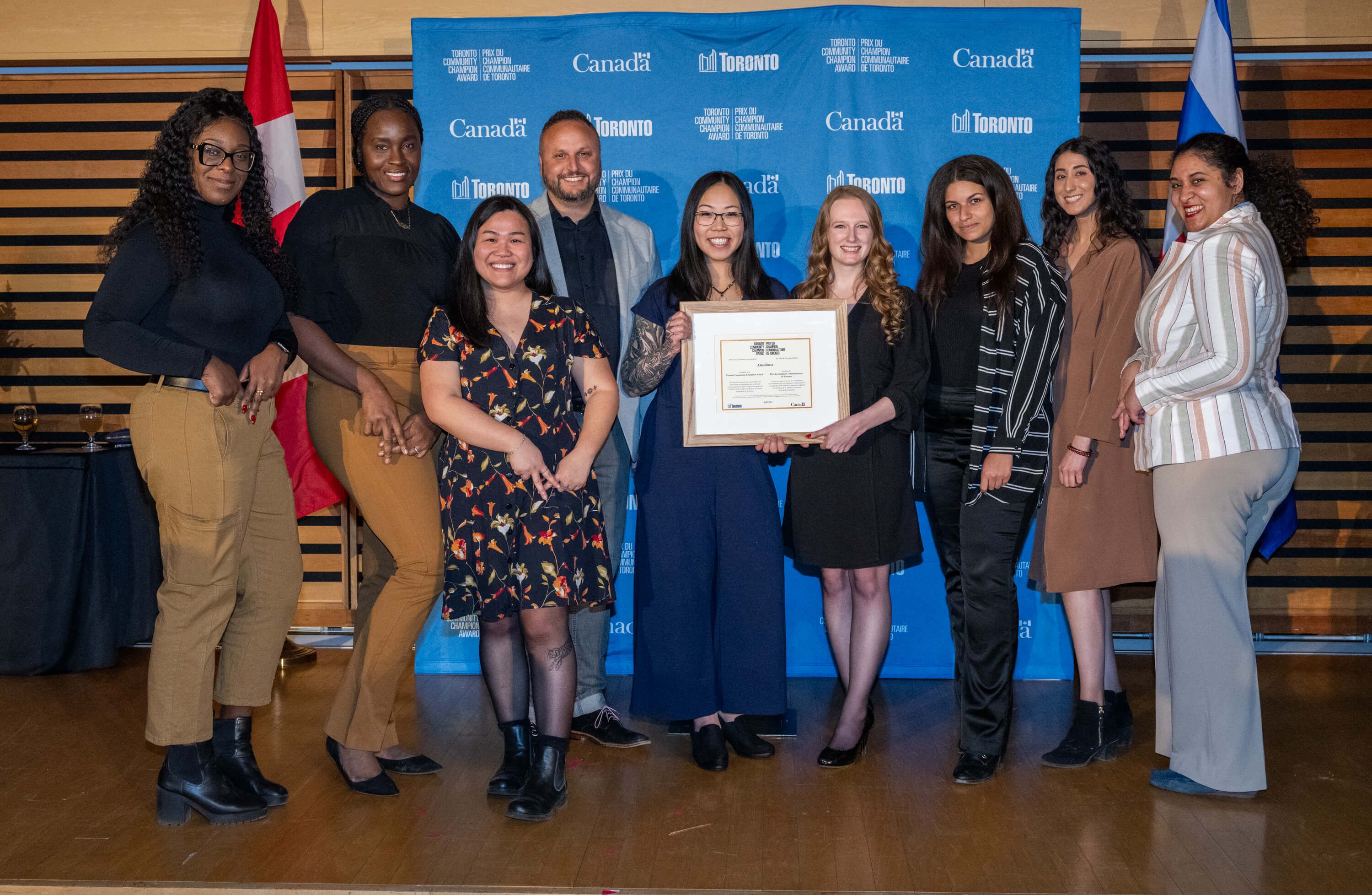 The Amadeusz staff celebrating their achievements at the Toronto Community Champion Award ceremony at the Bram & Bluma Appel Salon in the Toronto Reference Library
