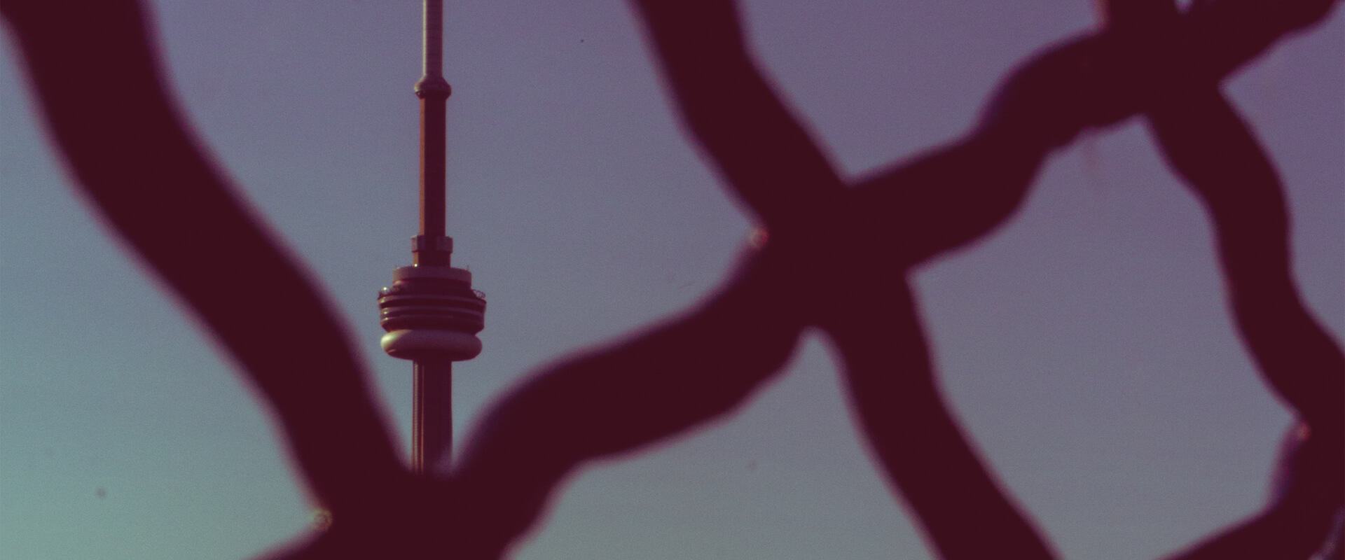 Photo of CN Tower through the fence